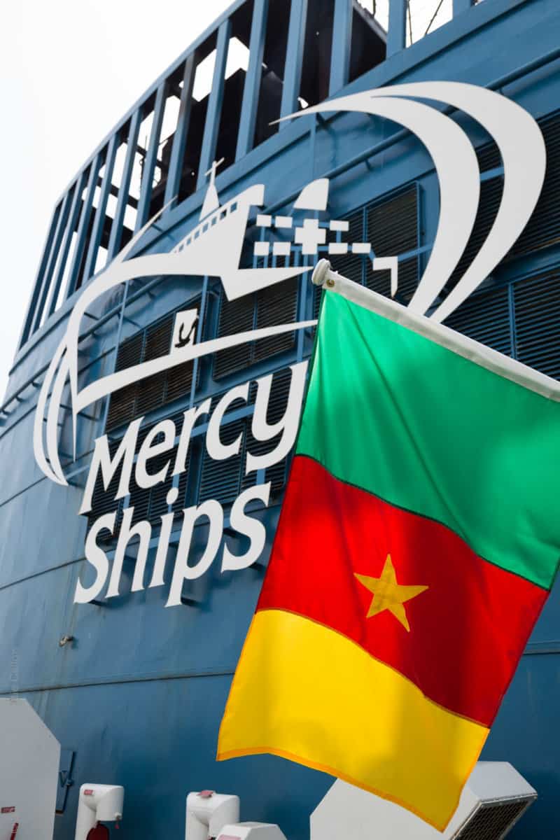 The Cameroon flag waves in front of the funnel.